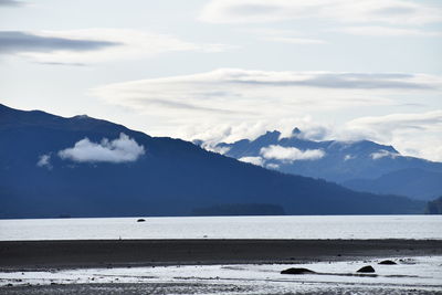Scenic view of sea and mountains against sky