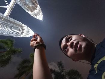 Low angle view of child holding umbrella against sky