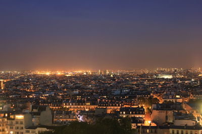 Illuminated cityscape against sky at night