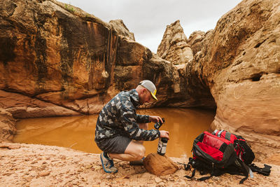 Backpacker prepares to treat his drinking water with iodine in desert