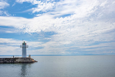 Beautiful view with a lighthouse on a pier by the water