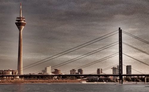 Bridge over river against cloudy sky