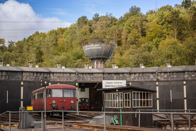 Train by railroad tracks against trees