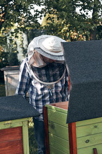 Beekeeper examining honey comb at yard