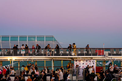 Group of people on railing against clear sky
