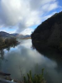 Scenic view of lake by trees against sky