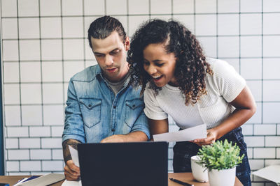 Business people discussing over laptop on table