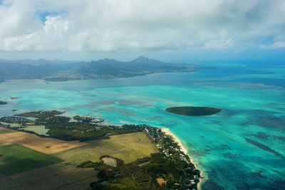 Aerial view of seascape against cloudy sky