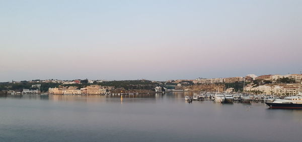 Scenic view of river by buildings against clear sky