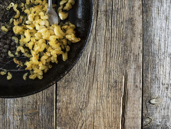 Directly above shot of macaroni pasta in pan on wooden table