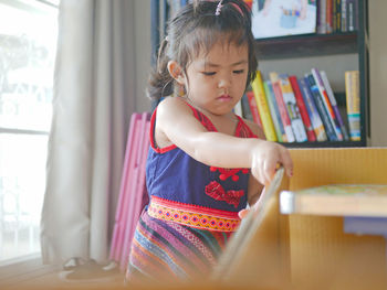 Cute girl holding book at home