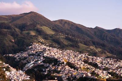 Aerial view of buildings and mountains against sky
