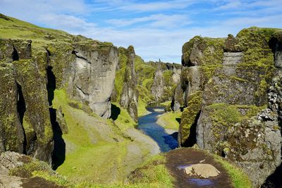 Idyllic view of river amidst rock formations on sunny day