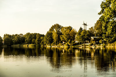 Scenic view of lake by trees against sky