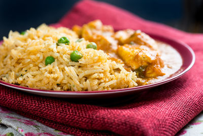 Close-up of rice in plate on maroon fabric