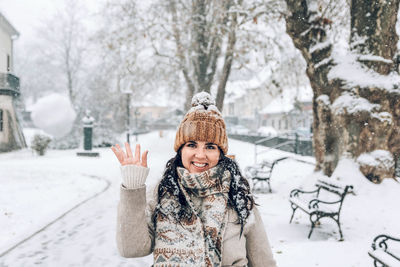 Portrait of smiling woman standing in snow