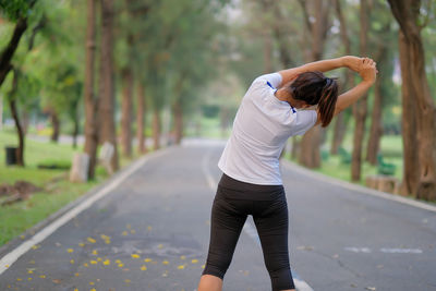 Rear view of woman standing on road