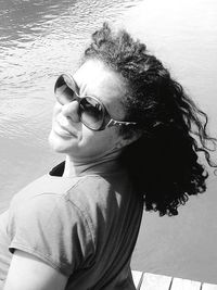 Portrait of woman wearing sunglasses on pier over sea