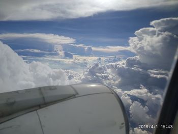 Airplane flying over clouds against sky