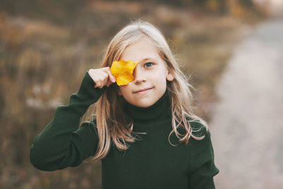 Portrait of a beautiful teenage girl with blond hair and blue eyes with a smile on her face 