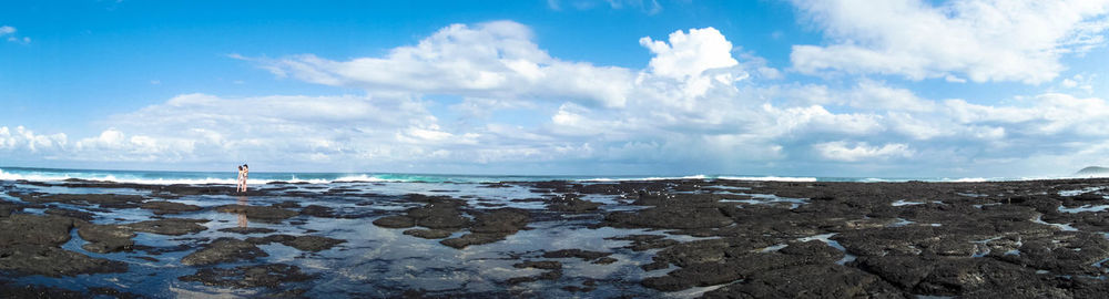 Panoramic view of rocks on beach against sky