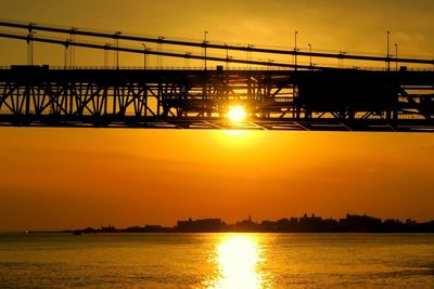 Bridge over calm lake at sunset