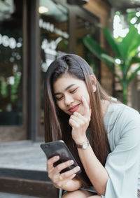 Young woman using mobile phone outdoors