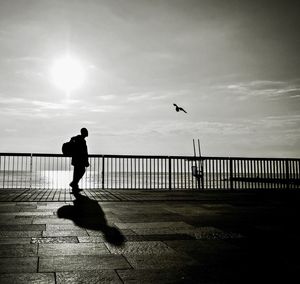 Silhouette of woman in sea at sunset