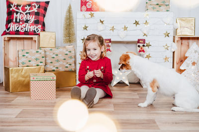 Little cute girl and jack russell dog at home during christmas time