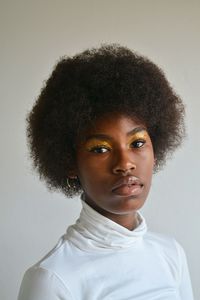 Close-up portrait of young woman against white background