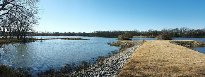 Scenic view of calm lake against clear blue sky