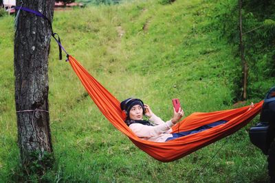 Rear view of woman sitting on grass