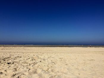 Scenic view of beach against clear blue sky