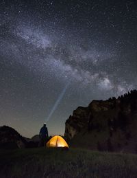 Man standing on field against sky at night