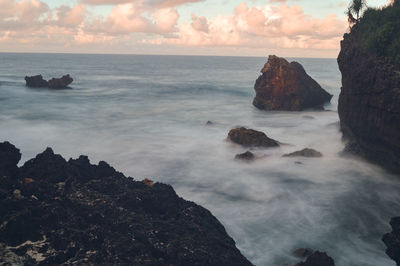 Scenic view of rocks in sea against sky