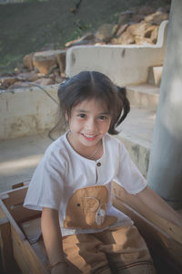 Portrait of a smiling girl sitting outdoors