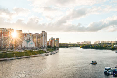 River amidst buildings in city against sky