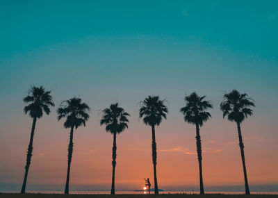 Silhouette palm trees against sky during sunset