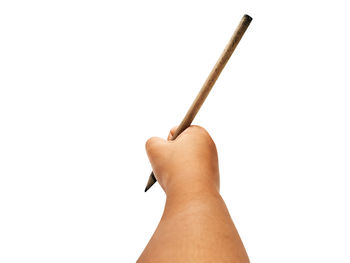 Close-up of hand holding wood against white background