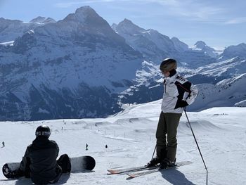 Rear view of people walking on snowcapped mountain