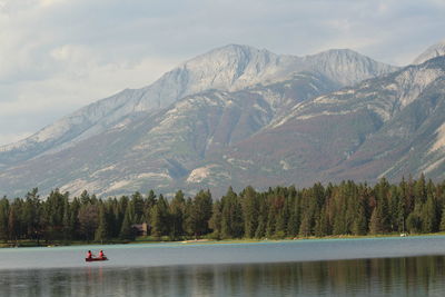 Scenic view of lake by mountains against sky