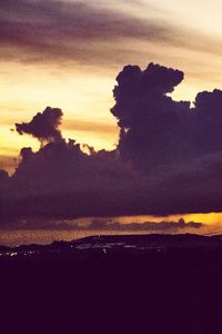 Scenic view of sea against dramatic sky during sunset