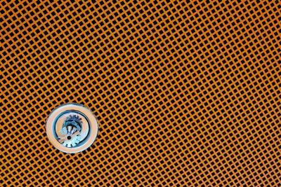 Low angle view of sprinkler on patterned ceiling