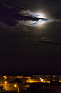 Illuminated cityscape against sky at night