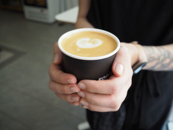 Midsection of woman holding coffee