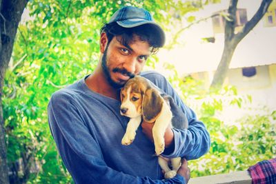 Portrait of man with dog against plants