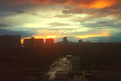 Buildings in city against sky at sunset