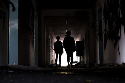 Rear view of silhouette people standing in building