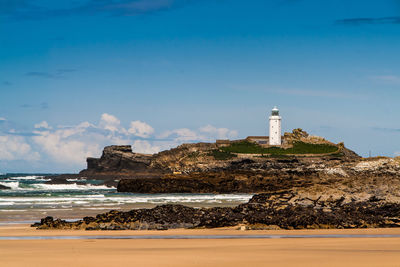 Lighthouse by sea against sky