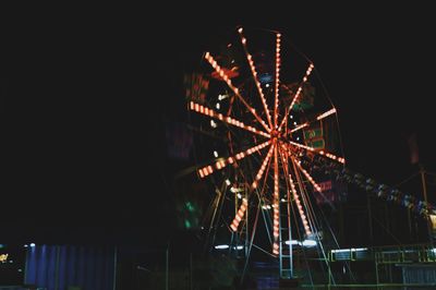 Low angle view of illuminated ferris wheel against sky at night